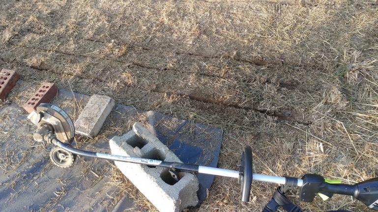 The edger attachment for our 80volt electric weed eater is used to make seeding trenches for Popcorn in a freshly uncovered space.